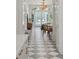 Hallway leading to a formal sitting room with luxury checkerboard flooring, high ceilings, and grand lighting at 71 E Bay St, Charleston, SC 29401