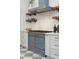 A modern blue stove is surrounded by white cabinets, gold hardware, marble countertops, and floating wood shelves at 71 E Bay St, Charleston, SC 29401