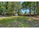Spacious backyard featuring lush green grass, storage shed and covered area, perfect for outdoor enjoyment at 7639 Hillandale Rd, North Charleston, SC 29420