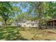 Backyard view of the home's exterior with lawn and mature trees at 7639 Hillandale Rd, North Charleston, SC 29420