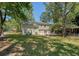 View of the home's exterior from the spacious backyard with lawn and mature trees provides a private, relaxing retreat at 7639 Hillandale Rd, North Charleston, SC 29420