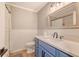 Bathroom with blue vanity, wainscotting, brushed nickel hardware and shower at 7639 Hillandale Rd, North Charleston, SC 29420