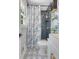 This bathroom features a blue tiled shower, blue and white decorative shower curtain, and floating shelves at 7639 Hillandale Rd, North Charleston, SC 29420