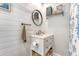Charming bathroom features shiplap walls, a round mirror, and a vanity with storage space at 7639 Hillandale Rd, North Charleston, SC 29420