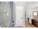 Inviting foyer with decorative glass door, white trim, and glimpse into the living room at 7639 Hillandale Rd, North Charleston, SC 29420