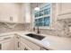 Bright kitchen features modern white cabinets, quartz countertops, a sleek black sink, and herringbone tile backsplash at 7639 Hillandale Rd, North Charleston, SC 29420