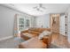 Comfortable living room with brown leather sofa, ceiling fan, and French door leading outside, next to staircase at 7639 Hillandale Rd, North Charleston, SC 29420