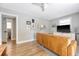 Bright living room featuring a brown leather sofa, television, and access to hallway and bath at 7639 Hillandale Rd, North Charleston, SC 29420