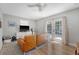 Cozy living room with wood floors, leather sofa, ceiling fan, and a French door providing lots of natural light at 7639 Hillandale Rd, North Charleston, SC 29420