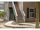 Close-up of condo entrance with a decorative 'hello' wreath on the front door and wooden stairway at 7935 Parklane Ct # A, North Charleston, SC 29418