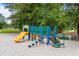 Community playground with colorful equipment near mature trees and a pond at 7935 Parklane Ct # A, North Charleston, SC 29418