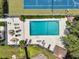 Aerial view of pool and tennis court surrounded by lush greenery and lounge seating areas at 8 Pony Ln, Charleston, SC 29407