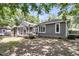 Home exterior featuring a sunroom, with a wooden fence, and lush foliage, offering privacy and charm at 8 Pony Ln, Charleston, SC 29407
