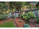 Home exterior with lush front yard landscaping, mature trees and garden beds at 8 Pony Ln, Charleston, SC 29407