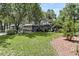 Charming home with lush landscaping, mature trees, and expansive front yard, creating a welcoming ambiance at 8 Pony Ln, Charleston, SC 29407