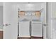 Efficient laundry room with white cabinets, shelving, and a full-sized washer and dryer set at 8 Pony Ln, Charleston, SC 29407