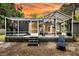 Outdoor screened porch featuring a hot tub, ceiling fan, lounge chairs, and string lights at 8 Pony Ln, Charleston, SC 29407