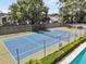 Private tennis court with pristine blue surface and lush landscaping in a beautiful community at 8 Pony Ln, Charleston, SC 29407
