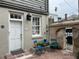 Charming courtyard featuring a bistro set, historic architecture, and lush potted plants at 84 Bull St # F, Charleston, SC 29401