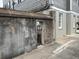 A concrete wall and black metal gate lead to a charming house with views of a tree-lined street at 84 Bull St # F, Charleston, SC 29401