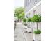 Charming building exterior with a sidewalk and decorative potted trees at 84 Bull St # F, Charleston, SC 29401