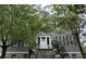 Charming home exterior with mature trees, white trim, and inviting front steps at 84 Bull St # F, Charleston, SC 29401
