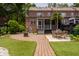 Backyard featuring brick pavers, synthetic turf, patio dining, and lush landscaping at 861 Center Park St, Charleston, SC 29492