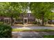 Classic brick townhouses with black shutters framed by mature trees on a picturesque street at 861 Center Park St, Charleston, SC 29492
