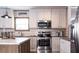 Modern kitchen featuring white cabinetry, stainless steel appliances, and dark wood-look flooring at 934 Tiger Loop, Saint Stephen, SC 29479