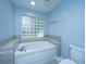Well-lit bathroom featuring a large soaking tub and a glass block window at 1005 Trotters Blvd, Summerville, SC 29483