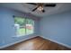 Well-lit bedroom with hardwood floors and a large window overlooking the backyard at 1005 Trotters Blvd, Summerville, SC 29483