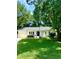 Charming white brick home featuring an attached garage, mature trees, and a well-manicured lawn at 1015 Jacksnipe Ln, Mount Pleasant, SC 29464