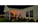 Night view of a home's exterior with a screened porch, landscaped yard, and elegant outdoor lighting at 1059 Fitzgerald Ct, Summerville, SC 29485
