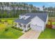 Stunning two-story home featuring a covered front porch, attached garage, and manicured lawn at 1059 Fitzgerald Ct, Summerville, SC 29485