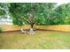 Beautiful backyard featuring a fire pit area, seating, mature tree, and a wood fence for privacy at 1077 Farmington Rd, Charleston, SC 29412