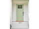 Close up of a charming front door with a fresh coat of light green paint at 1077 Farmington Rd, Charleston, SC 29412