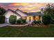 Charming single-story home with manicured landscaping, white siding and a dramatic sunset at 1077 Farmington Rd, Charleston, SC 29412
