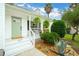 Inviting covered front porch with seating and lush greenery framing the entrance at 1077 Farmington Rd, Charleston, SC 29412