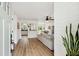 Bright, open-concept living space with hardwood floors, white walls, and a view into the kitchen at 1077 Farmington Rd, Charleston, SC 29412