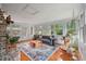 Sunroom featuring a gray sofa, brick fireplace, wood floors, and multiple windows at 109 Lakeview Dr, Summerville, SC 29485