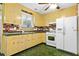 Vintage-style kitchen with yellow cabinetry, brick accents, white appliances, and charming, decorative details at 109 Rahway Rd, Goose Creek, SC 29445