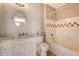 This bathroom features a classic white vanity, round mirror, and a tub shower with white and beige tile at 130 River Landing Dr # 2310, Daniel Island, SC 29492
