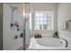 The elegant bathroom features a separate shower, soaking tub, and frosted windows, creating a luxurious, private experience at 132 Daniels Ridge Dr, Summerville, SC 29485