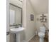 This charming bathroom features tile flooring, a pedestal sink, and decorative wall shelving, adding character to the space at 132 Daniels Ridge Dr, Summerville, SC 29485
