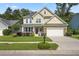 Charming two-story home featuring a manicured lawn, stone accents, and a cozy front porch with a white railing at 132 Daniels Ridge Dr, Summerville, SC 29485