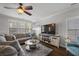 Spacious living room with a gray sectional sofa, ceiling fan, hardwood floors, and large windows for natural light at 132 Daniels Ridge Dr, Summerville, SC 29485