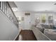 Inviting entryway with hardwood floors, stairs, and a spacious living area featuring a comfortable gray sectional sofa at 132 Daniels Ridge Dr, Summerville, SC 29485