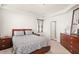 Well-lit bedroom featuring a wooden bed frame, matching dresser, and neutral carpeting at 132 Wild Holly Dr, Moncks Corner, SC 29461