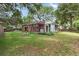 Beautifully landscaped backyard featuring a covered patio, a fire pit, and mature trees at 1549 N Avalon Cir, Charleston, SC 29407