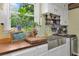A charming kitchen features stainless steel farmhouse sink, butcher block countertops, and white cabinetry at 1549 N Avalon Cir, Charleston, SC 29407